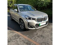 a silver bmw suv parked on the street