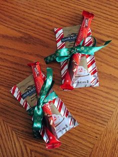 three wrapped candy bars sitting on top of a wooden table