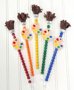 four different colored toothbrushes in plastic bags on a white table with brown handles