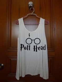 a harry potter tank top hanging up on a door with the words pott head printed on it