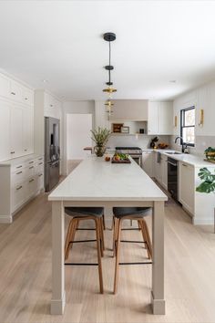 a kitchen with white cabinets and wooden floors