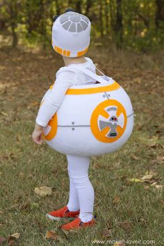 a little boy dressed as bbg from star wars is standing in the grass with his back to the camera