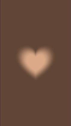 a heart shaped object is shown in the middle of a brown and black background with light coming from it