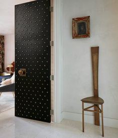 a room with a chair and a door that has holes in the side wall to make it look like something out of space