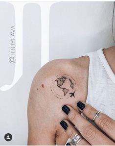 a woman's arm with a small world map tattoo on it