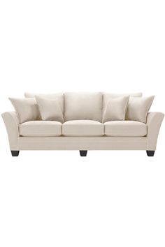 a white couch with four pillows on it's back and one arm facing the camera