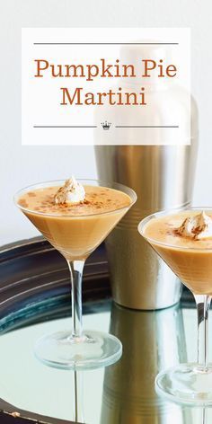 pumpkin pie martinis with whipped cream in coupe glasses on a round glass table next to a silver vase