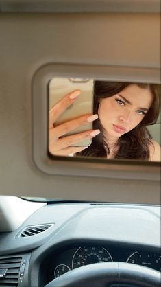 a woman's reflection in the mirror of a car