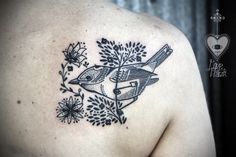 a bird tattoo on the back of a man's shoulder