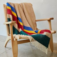 a wooden chair with a blanket on it