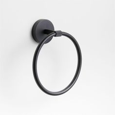 a black towel ring on a white wall with the handle extended to it's left side