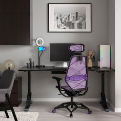 a purple office chair sitting in front of a desk with a computer on top of it