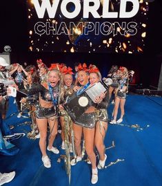 the cheerleaders are posing with their trophies in front of a world champion sign