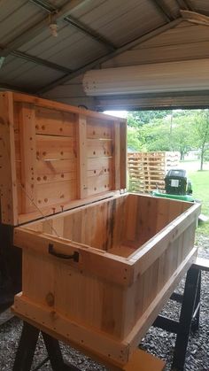 a large wooden box sitting on top of a metal stand next to a green truck