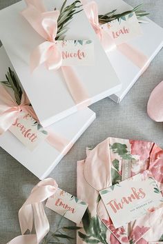 some pink and white cards with bows on them are sitting next to other paper goods