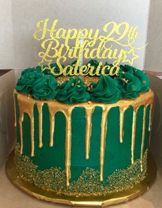 a green and gold birthday cake in a box