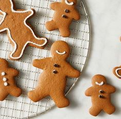 several ginger cookies on a cooling rack with one cookie cut out to look like people