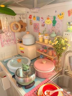 a kitchen filled with lots of pots and pans on top of a metal sink