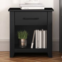 a black nightstand with books and plants on top