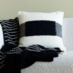 two black and white pillows sitting on top of a couch