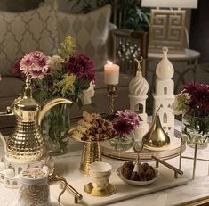 a table topped with vases filled with flowers next to candles and other decor items