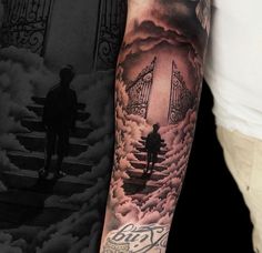 a man with a tattoo on his arm standing in front of an open gate and stairway