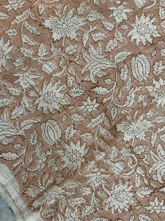 the fabric is brown and white with flowers on it's side, as well as leaves