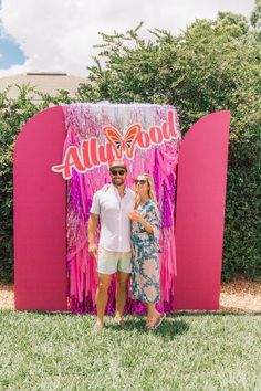 a man and woman standing in front of a sign