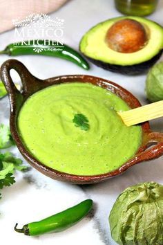 an avocado dip in a bowl surrounded by other ingredients