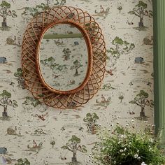 a mirror hanging on the wall next to a potted plant