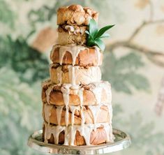 a three tiered cake sitting on top of a metal plate covered in icing