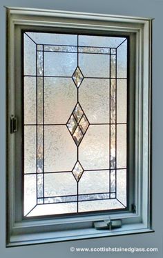 a close up of a stained glass window in a house with blue walls and white trim