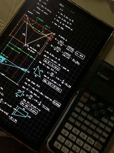 a calculator sitting on top of a table next to a laptop computer screen