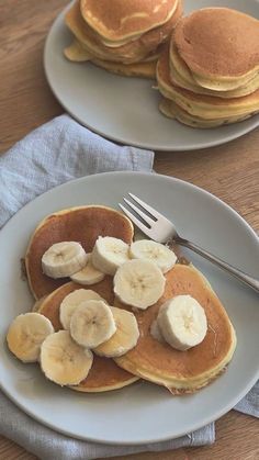 two plates with pancakes and bananas on them