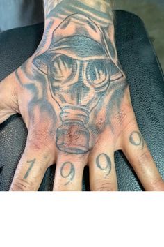 a man's hand with a gas mask tattooed on it