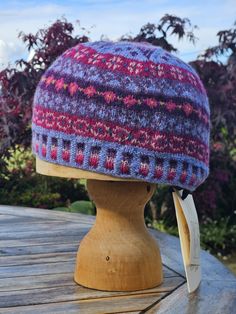 This colourful, hand knitted beanie in Shetland wool will keep you cosy as autumn approaches. The 'Peerie' design is influenced by the wee patterns that are between the main motifs in Fair Isle knitting and the crown is a spiral star. Cornflower blue main colour with pinks and purples . Medium size is suitable for adults who like a closer/neater fit; large is suitable for a larger head or for those who like a looser, slouchy look. Spiral Star, Hand Knit Hat, Shetland Wool, Knitted Beanie, Fair Isle Knitting, Knitted Hat, Skull Cap Beanie, Cornflower Blue, Skull Cap