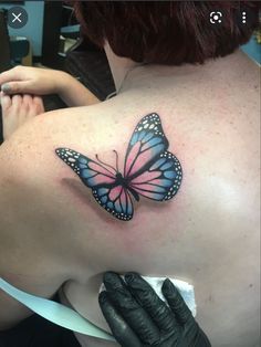 a woman with a butterfly tattoo on her back