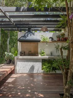 an outdoor kitchen is surrounded by trees and plants