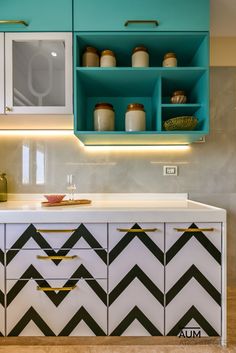 a kitchen with blue cabinets and black and white chevron pattern on the countertop