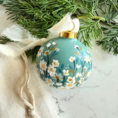 An extra special, hand-painted Christmas ornament perfect to gift or hang on your own tree! I carefully paint each ceramic ornament from scratch using textured acrylic to give each one a unique and beautiful dimensional effect. Each ornament is sealed with a satin varnish to keep it protected.  This listing includes one ornament featuring tiny white daisies atop a vintage green background.  *This ornament is READY TO SHIP and is the ONLY one of its kind. This year I painted each and every orname Diy Ornaments Paint, Handpainted Christmas Ornaments Ideas, Ornament Painting Ideas, Daisy Ornament, Hand Painted Christmas Balls, Christmas Ornament Painting, Painted Ornaments Christmas, Bougie Christmas, Purple Ornaments