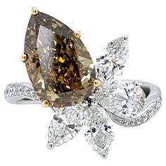 Unveil Elegance with a 3.12ct Fancy Deep Brown-Yellow Pear Diamond Ring Capture attention with this extraordinary pear-shaped diamond ring. The centerpiece is a captivating 3.12 carat natural fancy deep brown-yellow diamond, certified by the Gemological Institute of America (GIA) for authenticity and quality. Unlike traditional colorless diamonds, this rare gem boasts a rich, warm hue with an enchanting play of light. The VVS2 clarity ensures exceptional brilliance. Surrounding this stunning cen Luxury Brown Diamond Ring, Pear Diamond Ring, Pear Shaped Diamond Ring, Pear Diamond Rings, Colorless Diamond, Rare Gems, Deep Brown, Pear Diamond, Pear Shaped Diamond