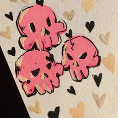 two pink skulls with black hearts on white paper