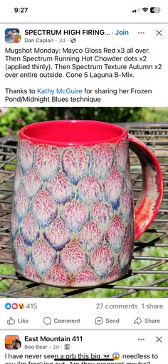 a red and white coffee mug sitting on top of a table