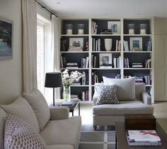 a living room filled with lots of furniture and bookshelves