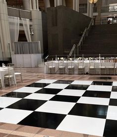 a large checkered floor with tables and chairs set up for an event or function