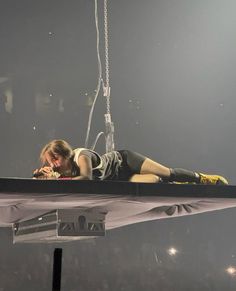 a woman laying on top of a suspended object