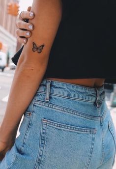 a woman with a butterfly tattoo on her left arm and the back of her stomach