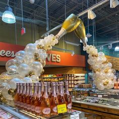 balloons and champagne are hanging from the ceiling in a store