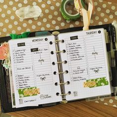 an open planner book sitting on top of a wooden table