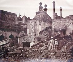 an old black and white photo of men standing in front of a building with two towers